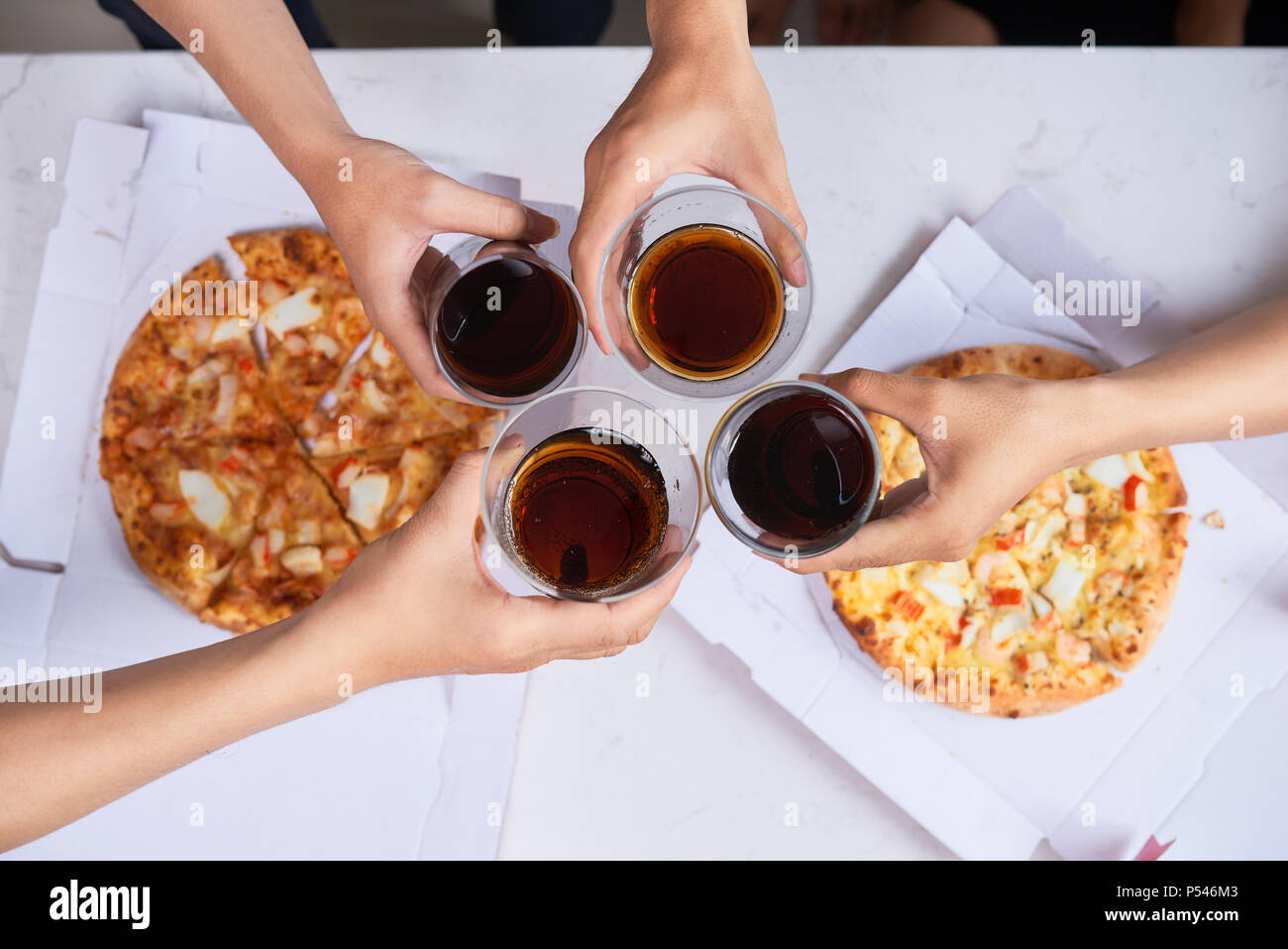 Prost! Top bis 7/8 Blick auf schön serviert Holztisch mit schmackhaften Gerichten und Snacks, Freunde sind das Toasten mit Brille von Soft drink Stockfoto