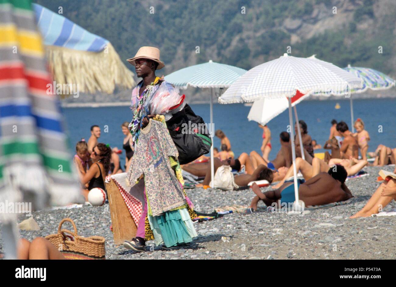 Afrikanische Einwanderer street vendor am Strand von Riva Trigoso (Ligurien, Italien) - venditore ambulante immigrato Africano sulla Spiaggia di Riva Trigoso (Ligurien, Italien) Stockfoto