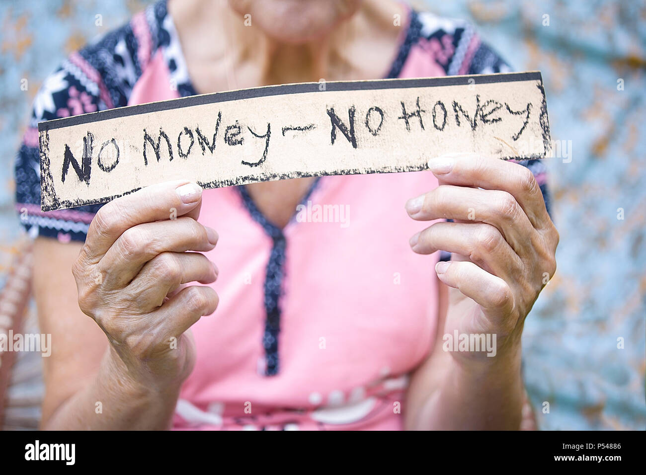 Weibliche Hände halten ein Papier mit Text kein Geld - kein Honig Stockfoto