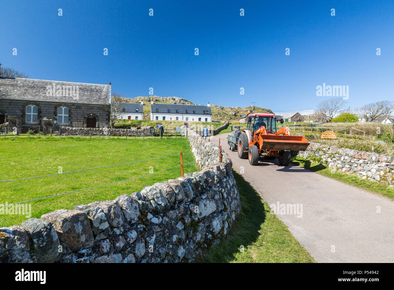 Ein Traktor ist es entlang der Straße 'main' der Hebriden Insel Iona, Argyll und Bute, Schottland, Großbritannien Stockfoto