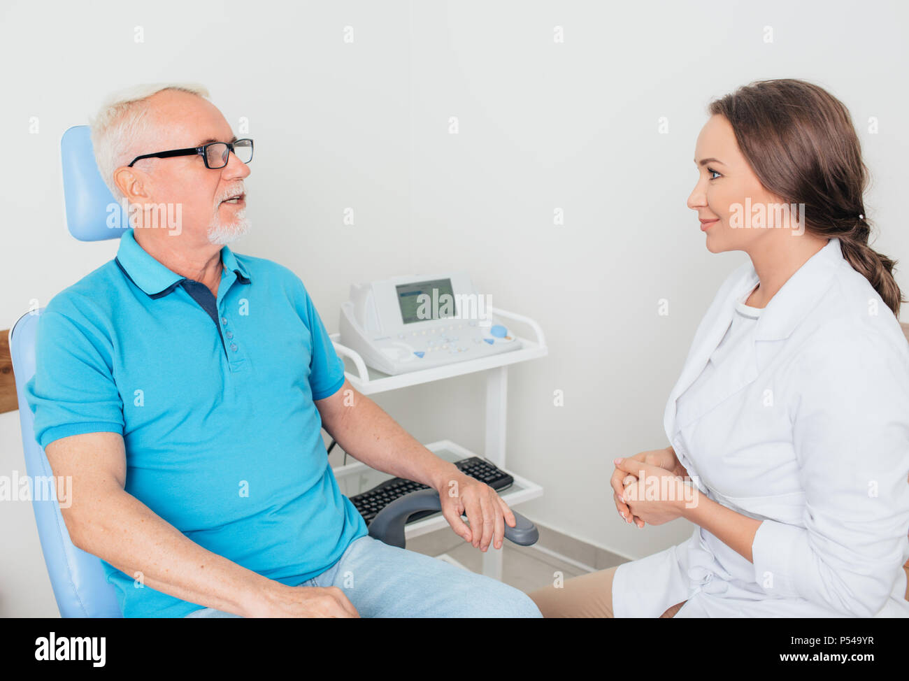 Arzt im Gespräch mit älteren Patienten in der Arztpraxis Stockfoto