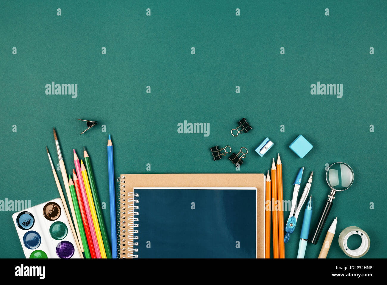 Der Schüler Schreibtisch mit stationären auf grünem Hintergrund. Vorbereitung auf die Schule. Stockfoto