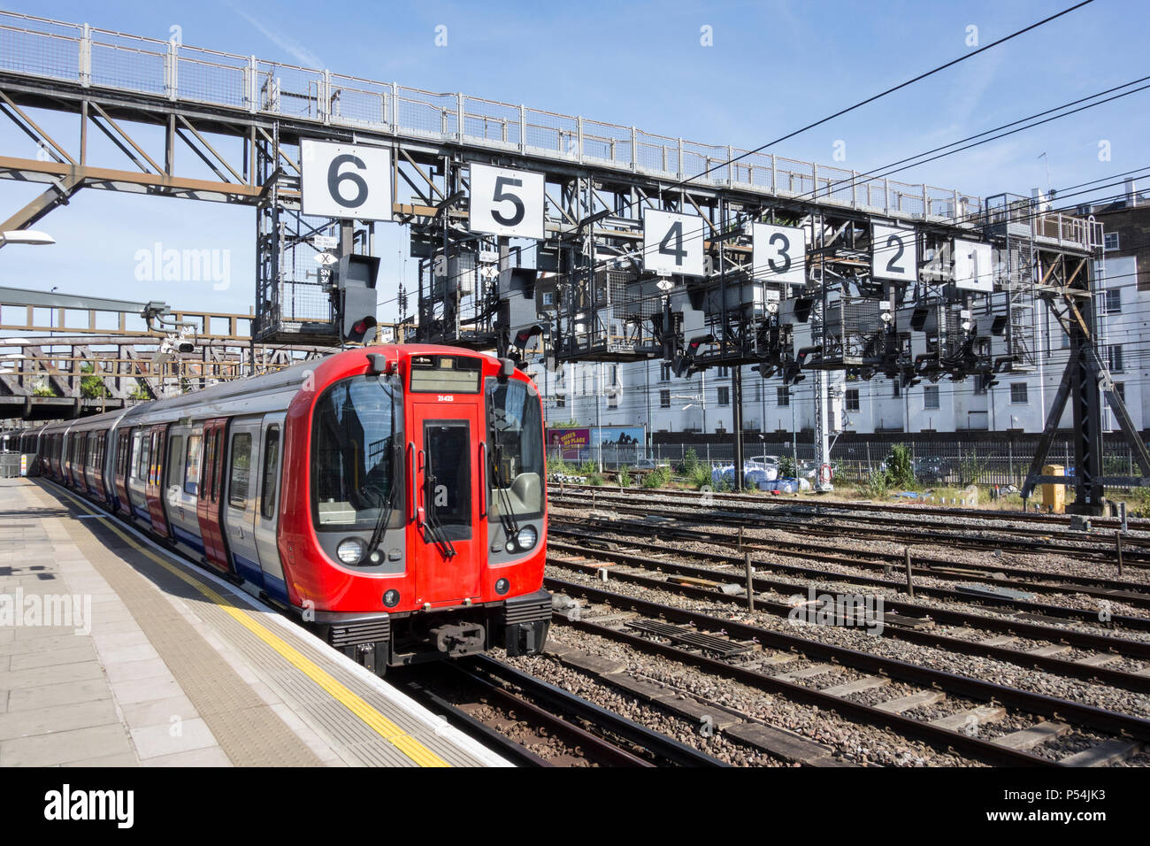 Ein Hammersmith und City Line Circle Line Zug vorbei unter dem Royal Oak Signalisierung gantry zur Paddington Station verlassen, London, UK Stockfoto