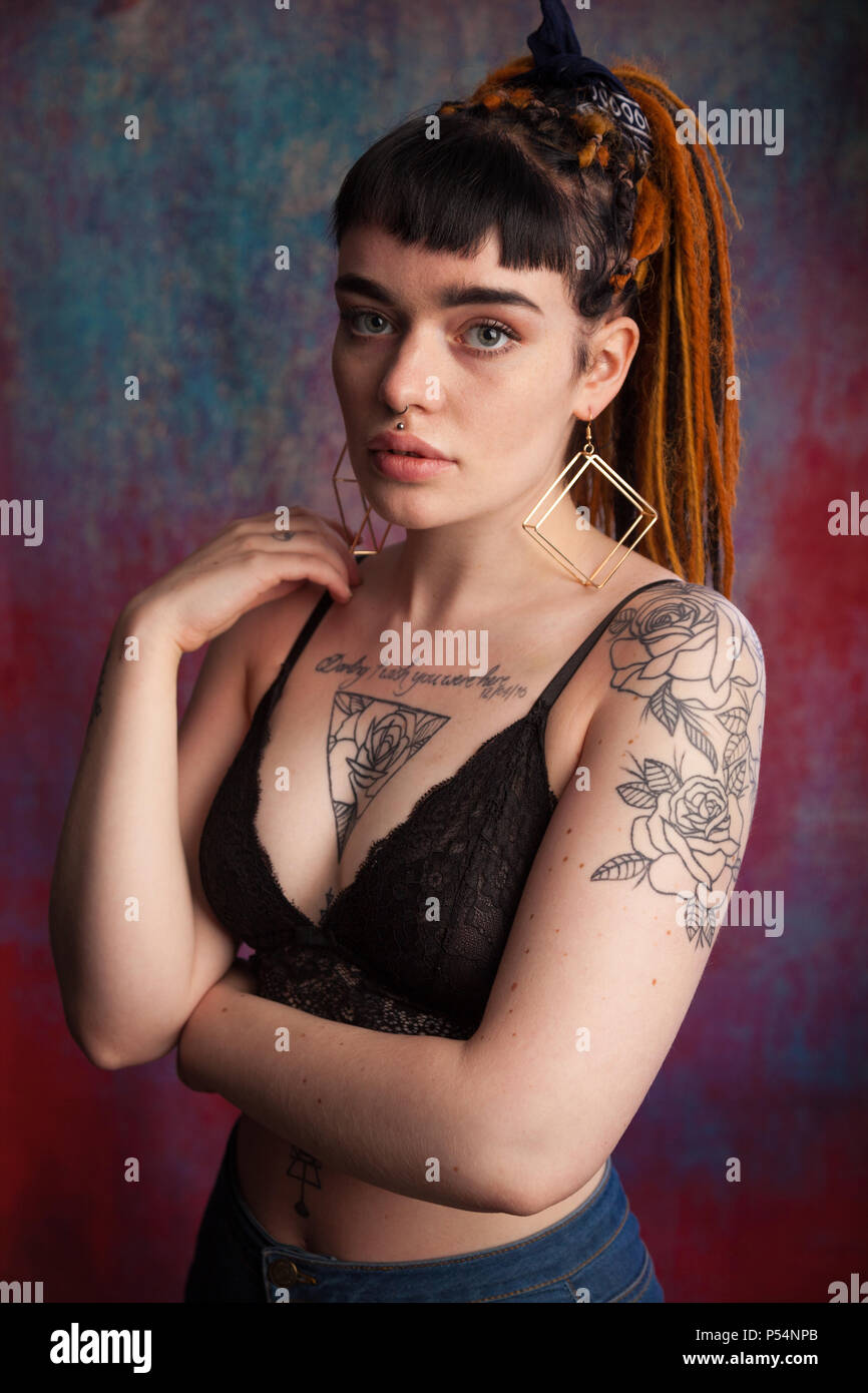 Alternative junge Frau mit Dreadlocks und Tattoos suchen, Fife, Schottland. Stockfoto