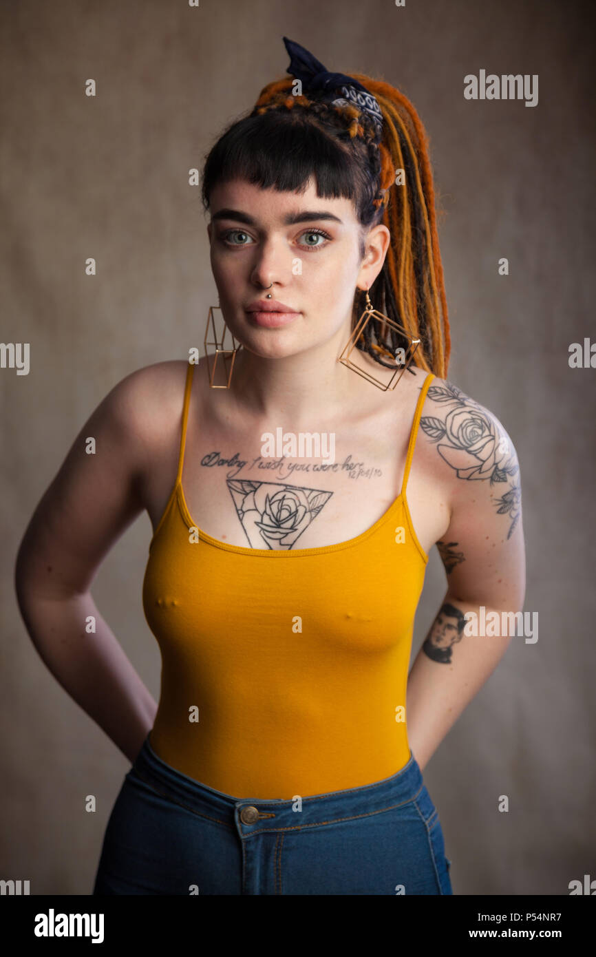 Junge Erwachsene Frau mit Tattoos und durchbohrte Brustwarzen, Fife, Schottland. Stockfoto