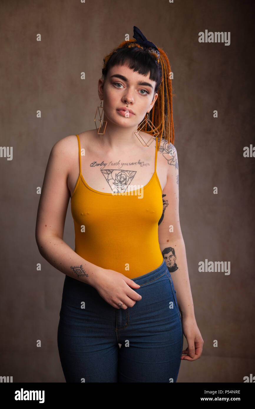 Junge Erwachsene Frau mit Tattoos und durchbohrte Brustwarzen, Fife, Schottland. Stockfoto