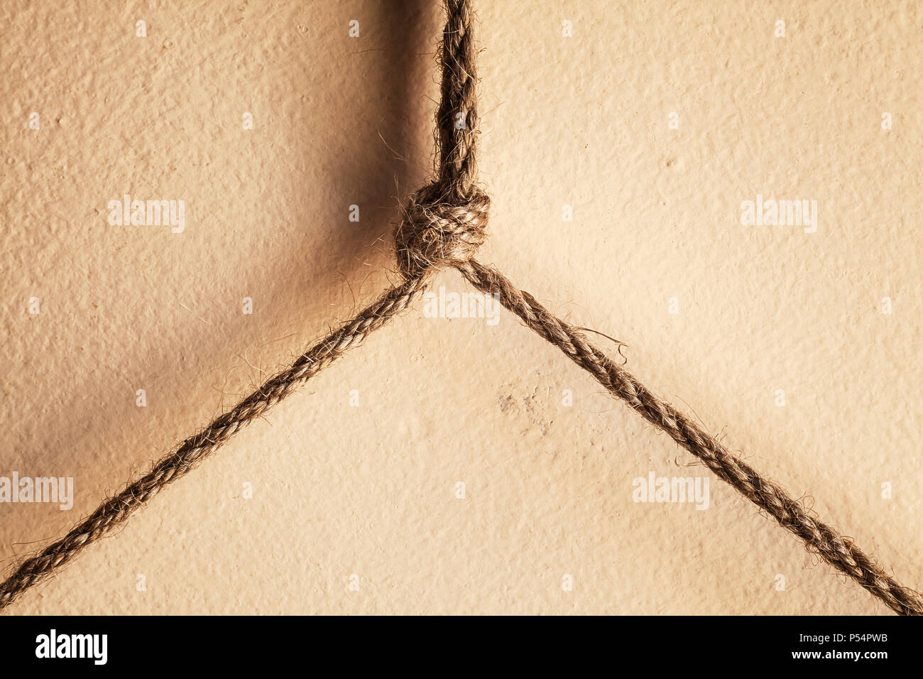 Abstrakte Komposition von kleinen Seile und Knoten über die Mauer. Stockfoto