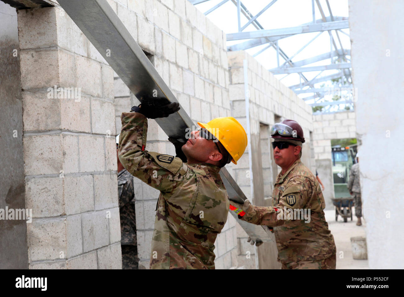 Us-Armee Sgt. Anthony Carrillo (links) und Sgt. Anthony Carrillo Herrero (rechts), beide mit der 485Th Engineer Company, aus Arlington Heights, Illinois, sorgfältig führt eine Verstrebung für Ingenieure, während eine neue Klinik Gebäude im Doppelzimmer Kohl, Belize, 10. Mai 2017 leitete. Dies war eine der letzten Balken das Dach des neuen Doppel Kopfkohl Klinik während über den Horizont 2017 zu beenden. BTH 2017 ist ein US Southern Command - geförderte, Armee südlich-led-Übung für humanitäre und technische Dienstleistungen für die Gemeinschaften in der Notwendigkeit, die Unterstützung der USA für Belize zur Verfügung zu stellen. Stockfoto