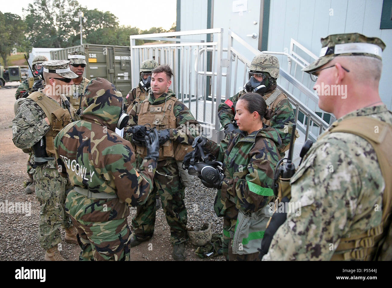 HUNTER LIGGETT, Calif. (10. Mai 2017) - steelworker 3. Klasse Justin Cann und Bau Elektriker 3. Klasse Dianna Borja, zu Naval Mobile Konstruktion Bataillon (NMCB) 4, ihre Gasmasken entfernt als Teil der Dekontamination verfahren nach einem simulierten chemischen, biologischen und radiologischen (CBR) Angriff bei logistischen Staging Area (LSA) Barnes im Fort Hunter Liggett, Calif. während der bataillone' Feld Übung, Mai 10 zugeordnet. Die Ausbildung ist so konzipiert, dass alle Aspekte der Defensive und operativen Fähigkeiten des Bataillon von Manning eine kämpfende Position auf der Übung Stockfoto