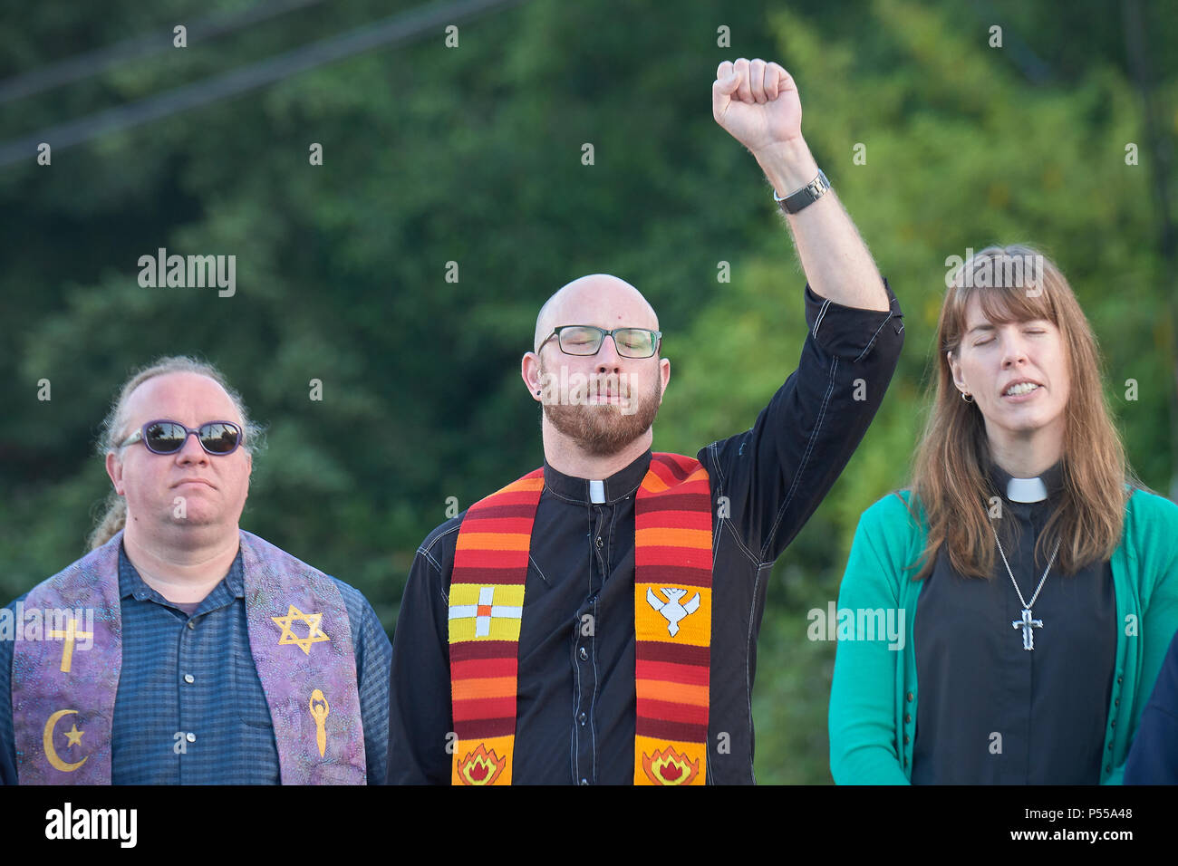 Seatac, Washington, USA. 24 Juni, 2018. Klerus Beten vor dem Zaun der Federal Detention Center in Seatac, Washington, Anfang Juni 24 während einer Gebetsvigil in Unterstützung der Zugewanderten Eltern im Gefängnis, die von ihren Kindern getrennt wurden. Die mahnwache wurde durch die Vereinigte Methodistische Kirche gefördert. Credit: Paul Jeffrey/Alamy leben Nachrichten Stockfoto