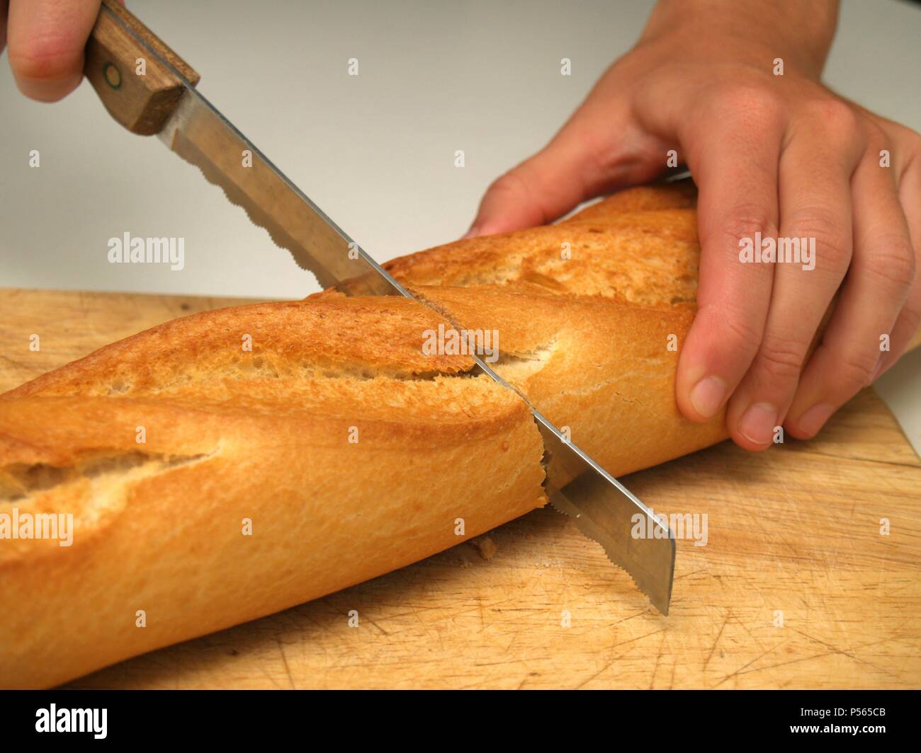 Persona cortando una Barra de pan. Stockfoto