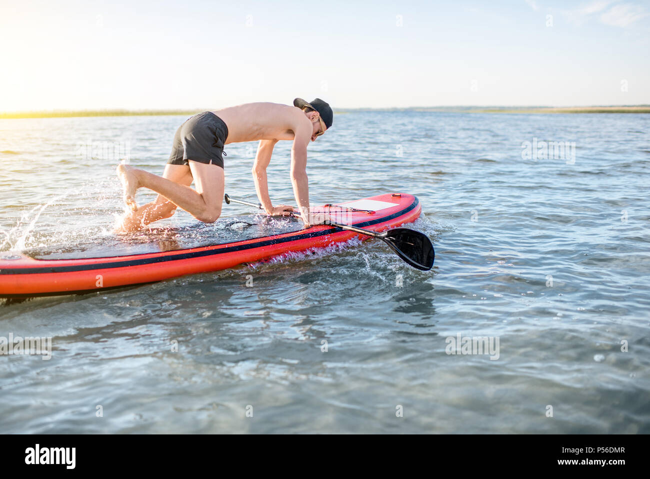 Mann paddleboarding auf dem See Stockfoto