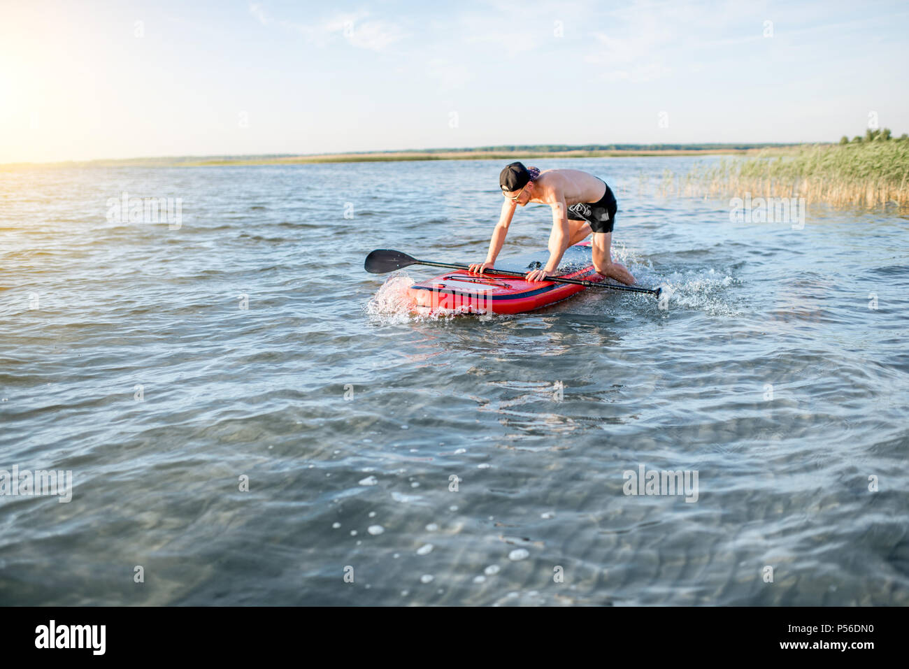 Mann paddleboarding auf dem See Stockfoto