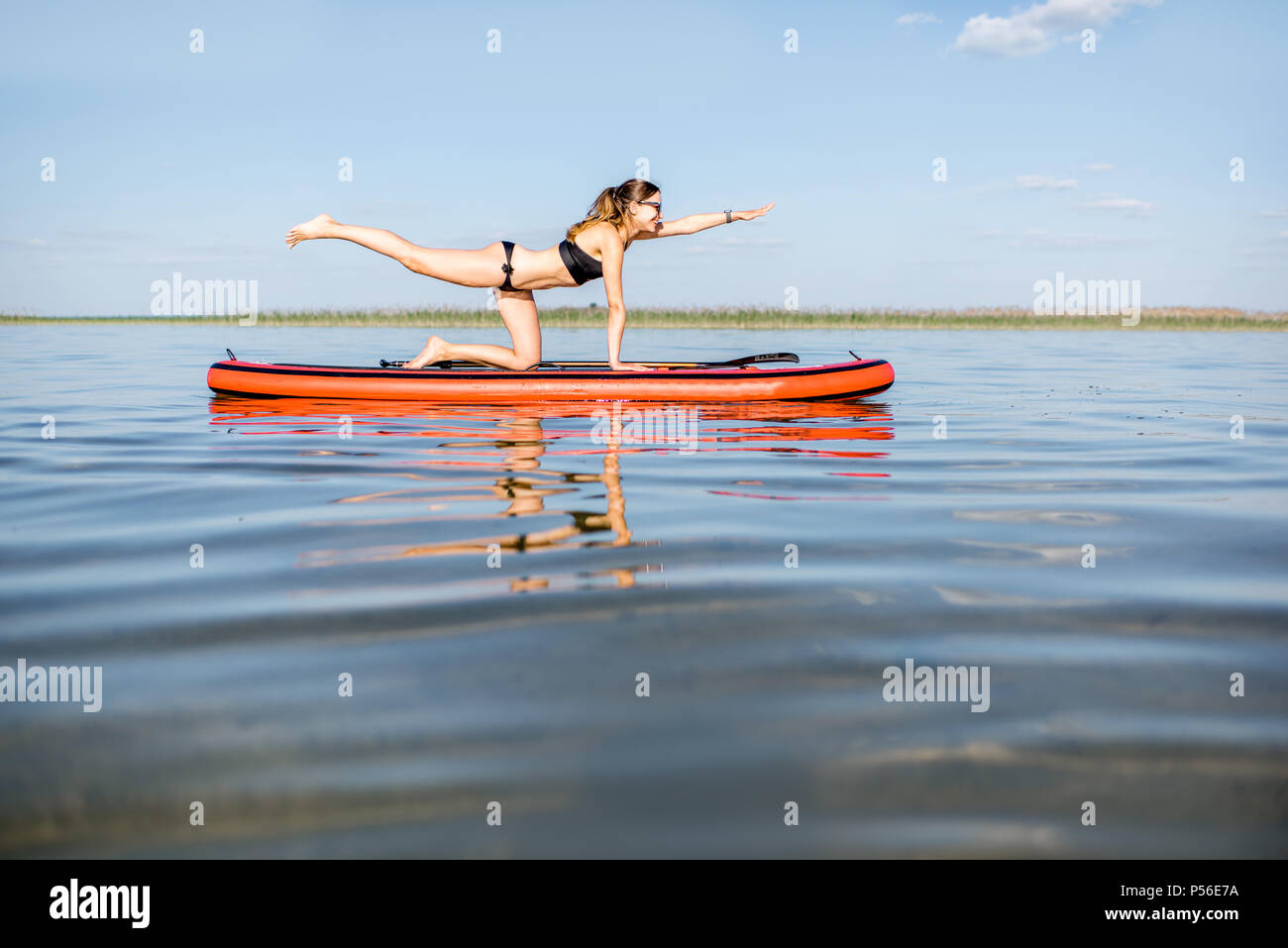 Frau Yoga auf dem paddleboard Stockfoto