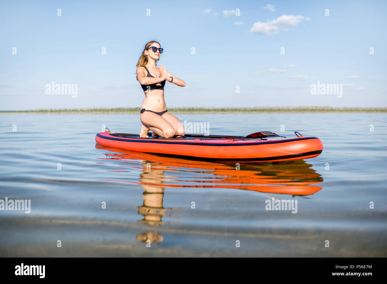 Frau Yoga auf dem paddleboard Stockfoto