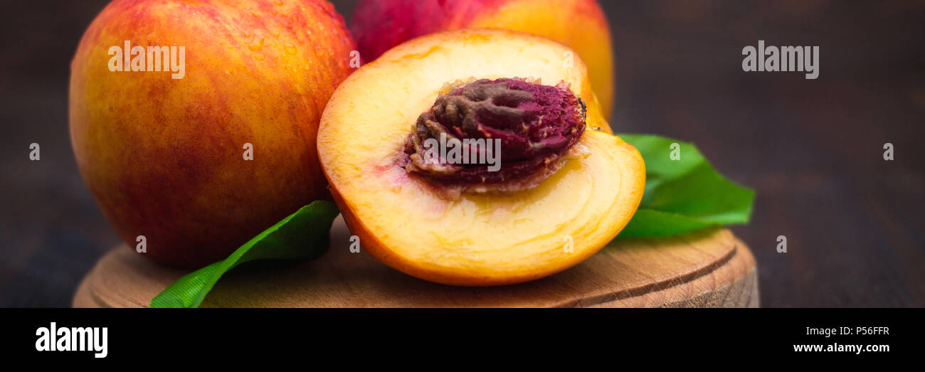 Reife Pflaumen, Nektarinen und Brugnolen an einem hölzernen Tisch. Reife Früchte auf einer rauhen Holz- Hintergrund. Rustikale Küche. Stockfoto