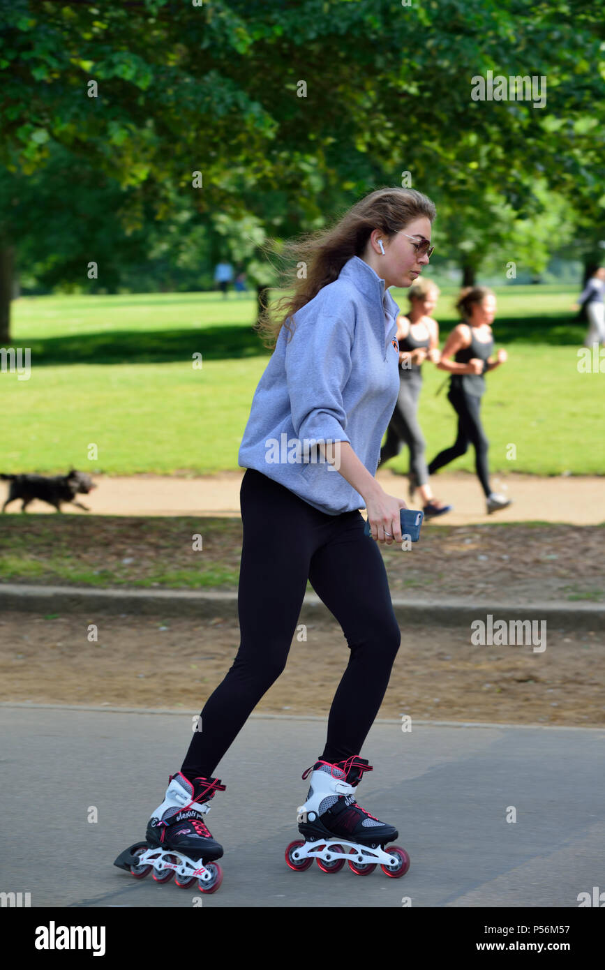 Junge Frau In-line Skating, Hyde Park, London, Vereinigtes Königreich Stockfoto