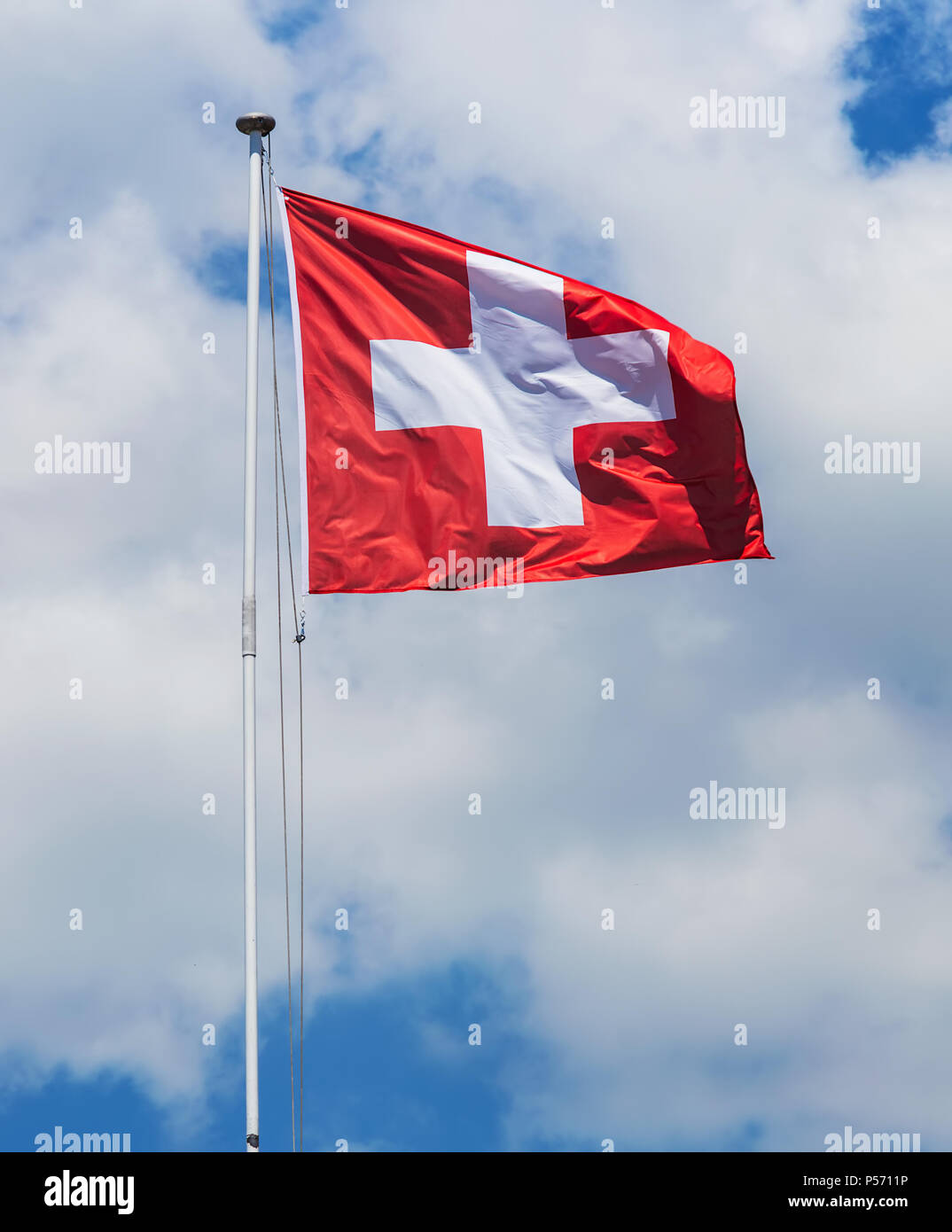 Flagge der Schweiz gegen bewölkter Himmel auf der windigen Tag. Stockfoto