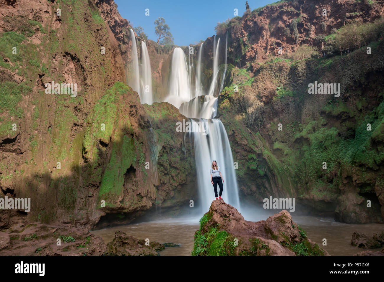 Junge Frau stehen auf einem Stein vor ouzoud Wasserfälle und Kaskaden, Cascades d'Ouzoud, Fluss Oued Tissakht, Mittlerer Atlas Stockfoto