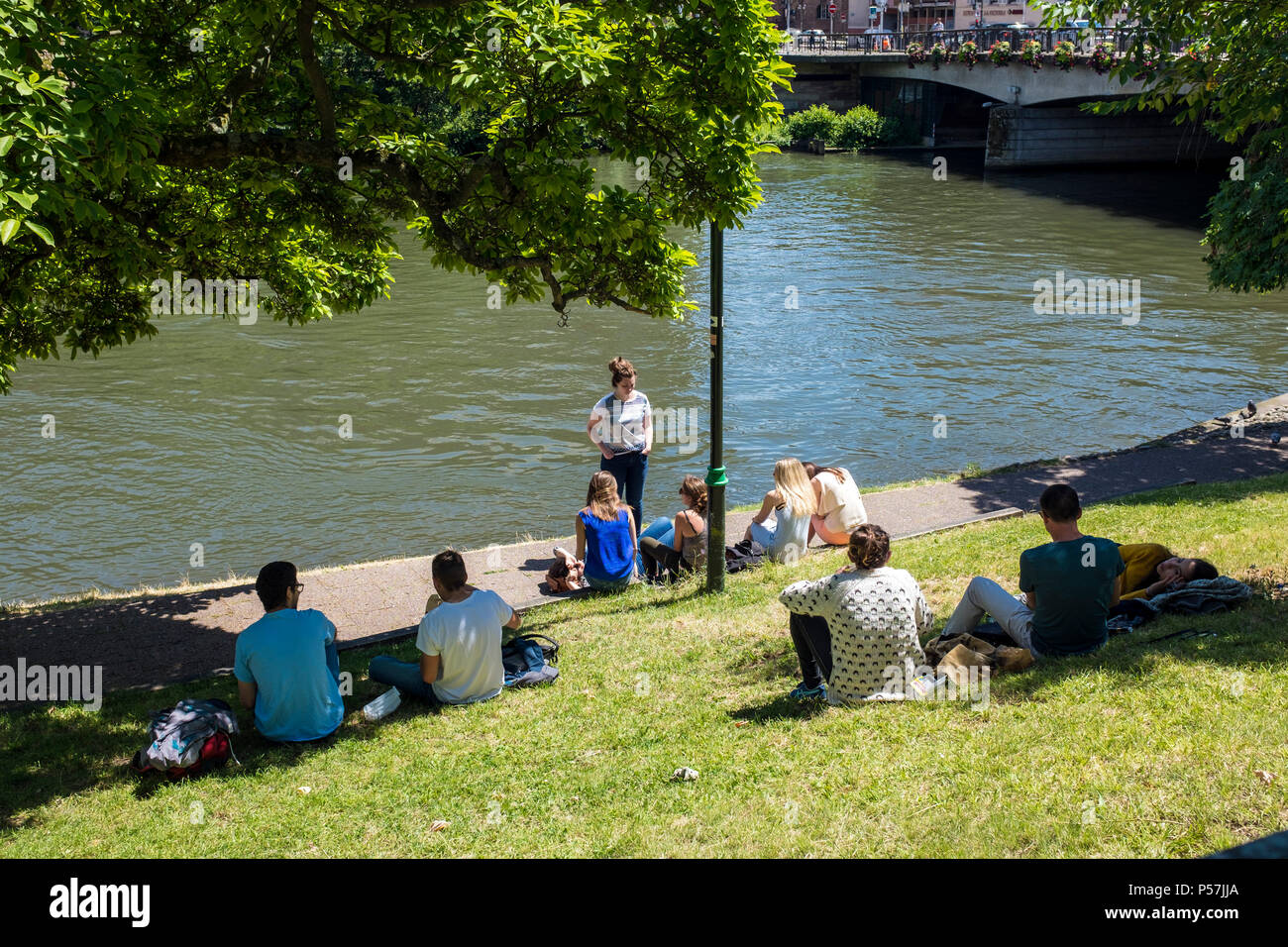 Straßburg, Schüler entspannen auf Ill Bank, Frühling, Elsass, Frankreich, Europa, Stockfoto