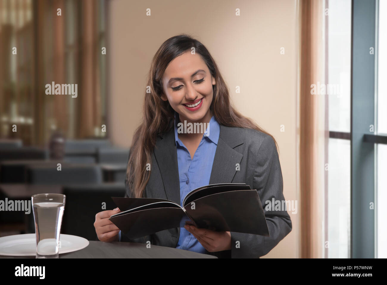 Geschäftsfrau lesen Magazin auf Tisch Stockfoto