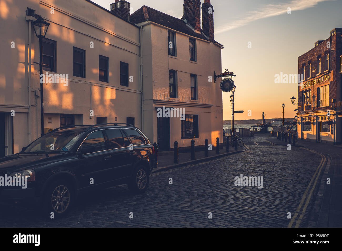 Auto auf gepflasterten Straßen in der Nähe eine Kneipe in Portsmouth bei Sonnenuntergang geparkt Stockfoto