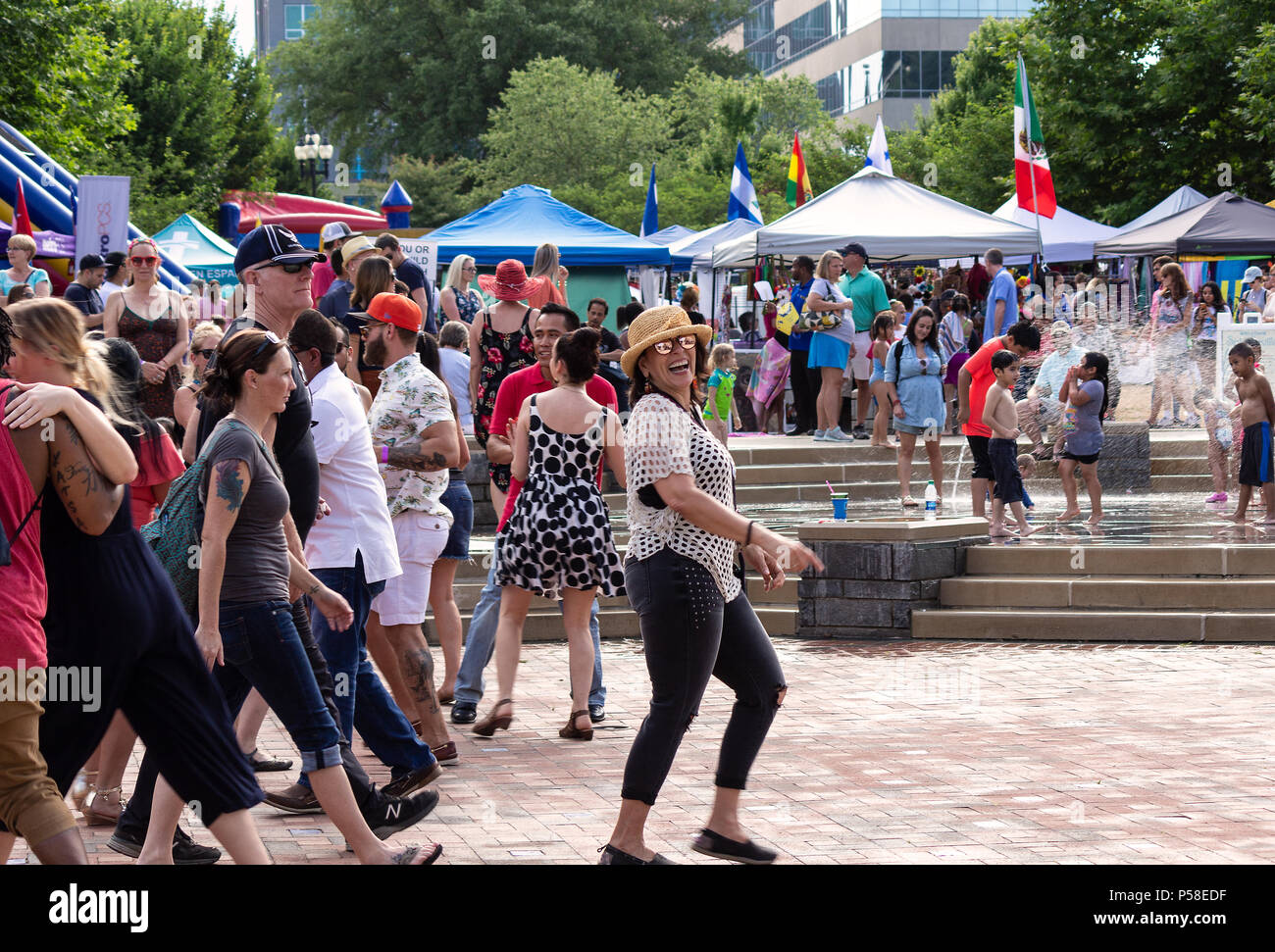 Eine Frau lacht beim Fotografen, Wandern in der Menge vor der Kinder im Wasser spielen Funktion in Asheville, NC, USA, im Hola Carolina Stockfoto