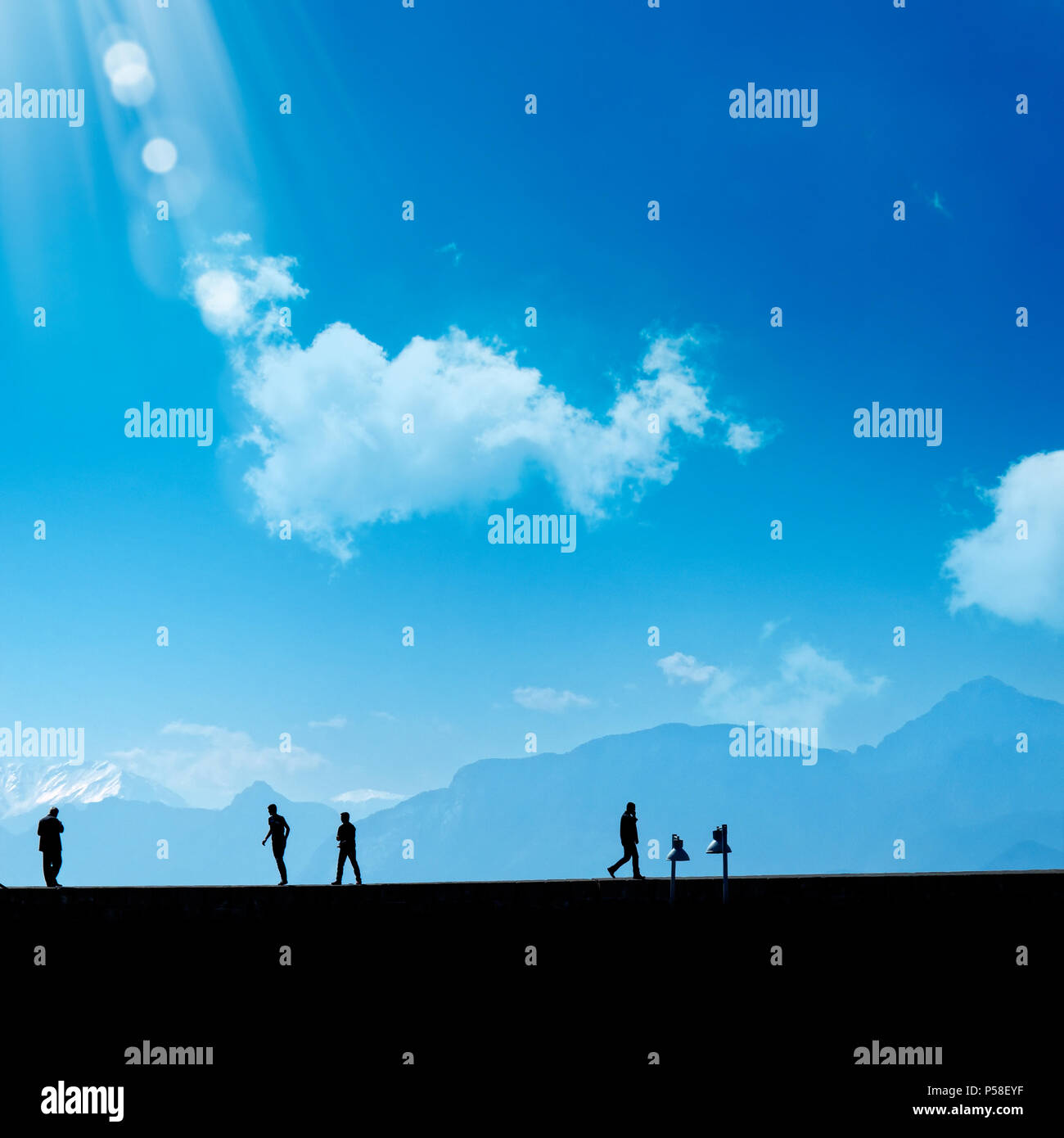 Silhouette Menschen entspannend auf der Straße über blauen Himmel und hohe Berge Stockfoto