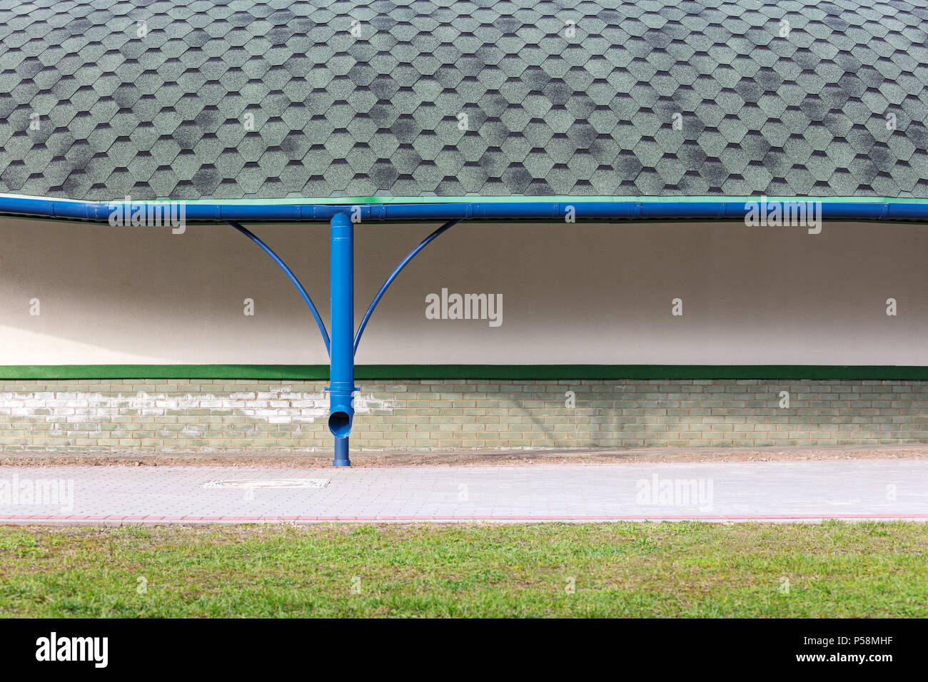 Neuen grauen Asphalt Schindeldach mit blau Metall Regenrinne Stockfoto