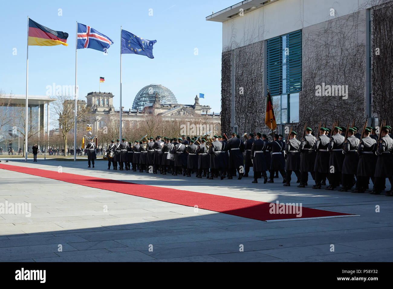 Berlin, Deutschland - Blick auf den Ehrenhof des Bundeskanzleramtes mit dem roten Teppich für Besuch aus Island. Das Personal band und das wachbataillon März in. Stockfoto