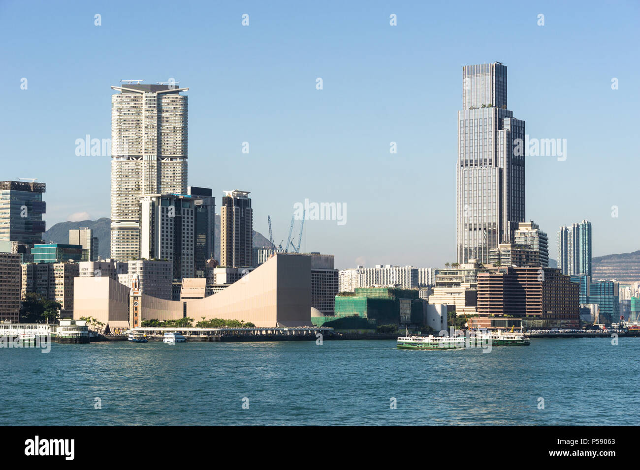 Skyline von Kowloon in Tsim Sha Tsui Blick über den Victoria Harbour in Hong Kong an einem sonnigen Tag in China SAR. Stockfoto