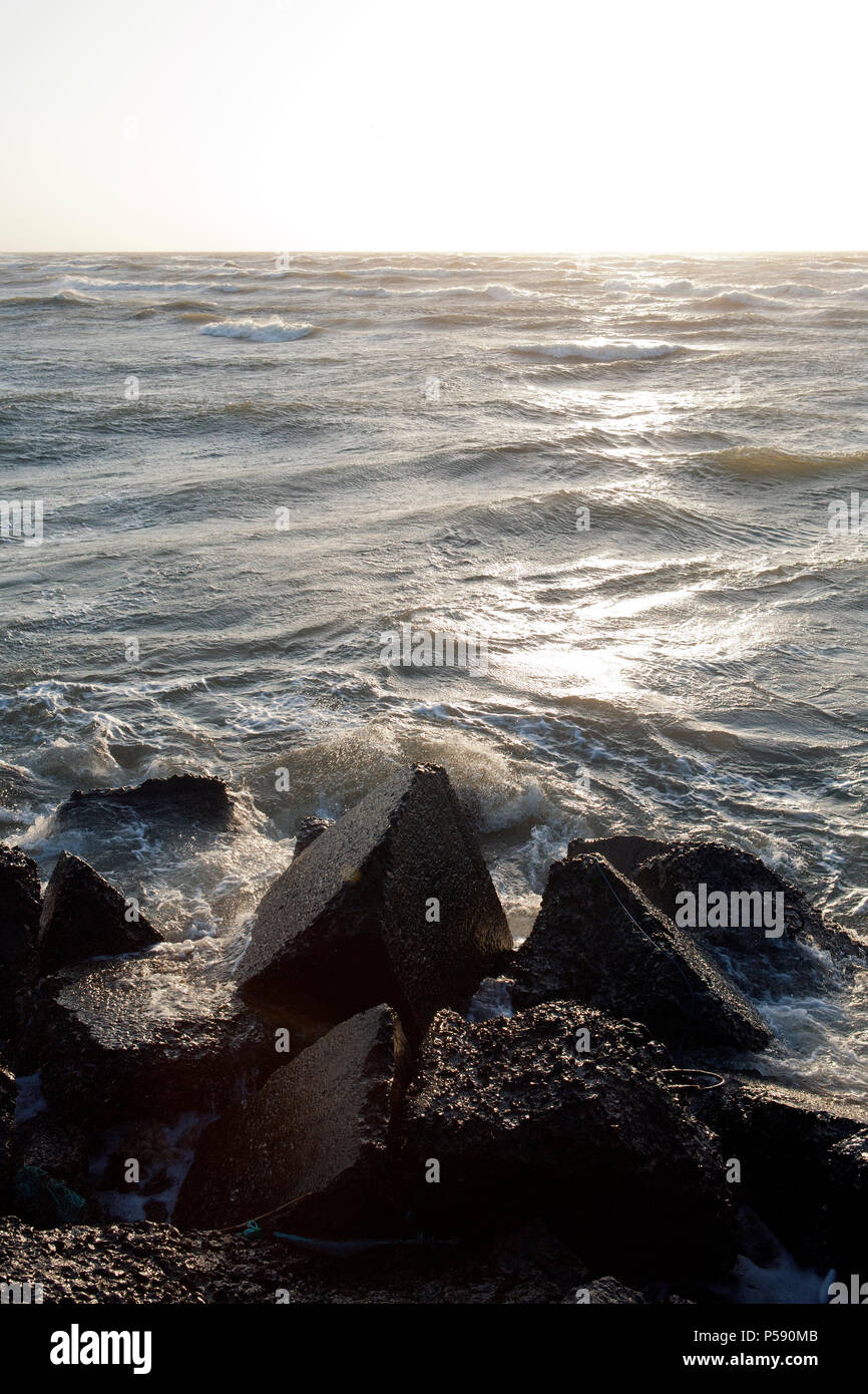 Wellen brechen sich am felsigen Pier an der Ostseeküste in Liepaja, Lettland Stockfoto