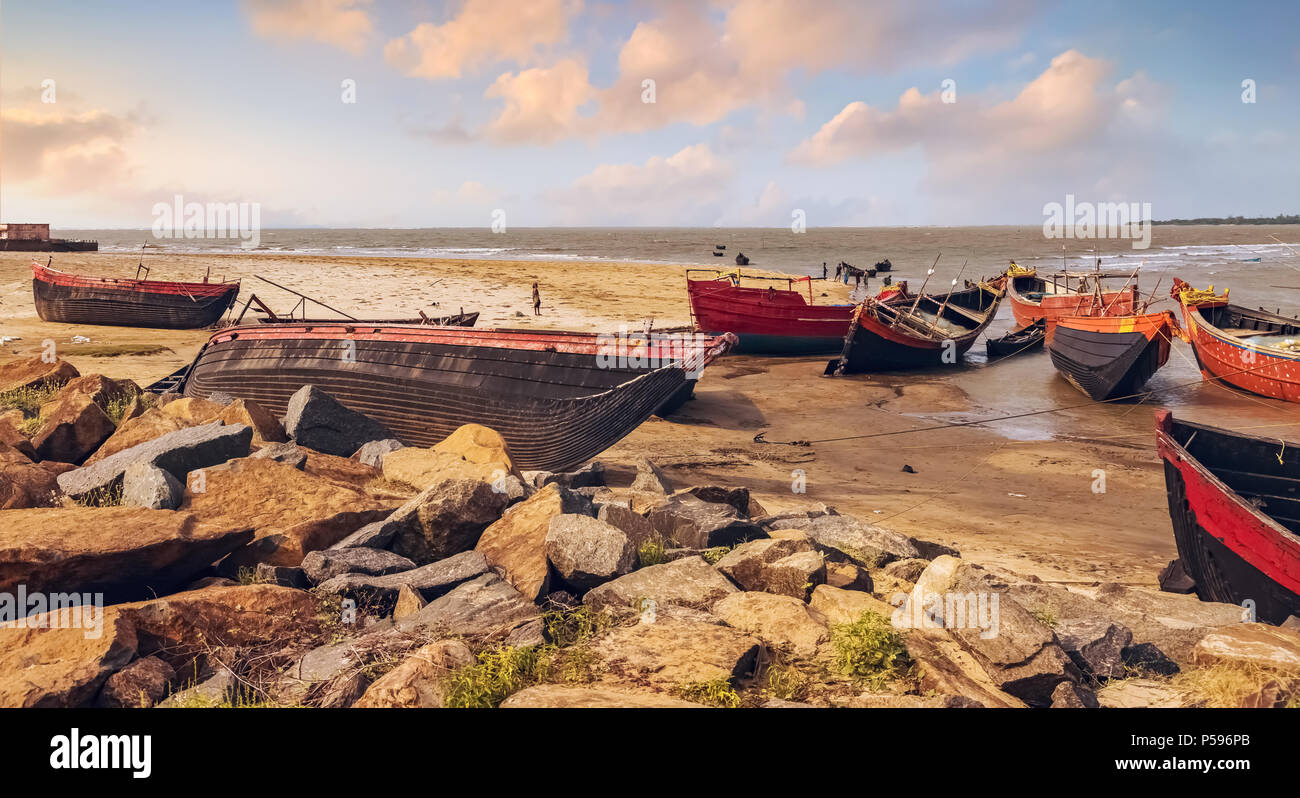 Holz- indische Fischerboote angedockt in Orissa Küsten Creek bei Sonnenuntergang warten auf hoher See tide. Stockfoto