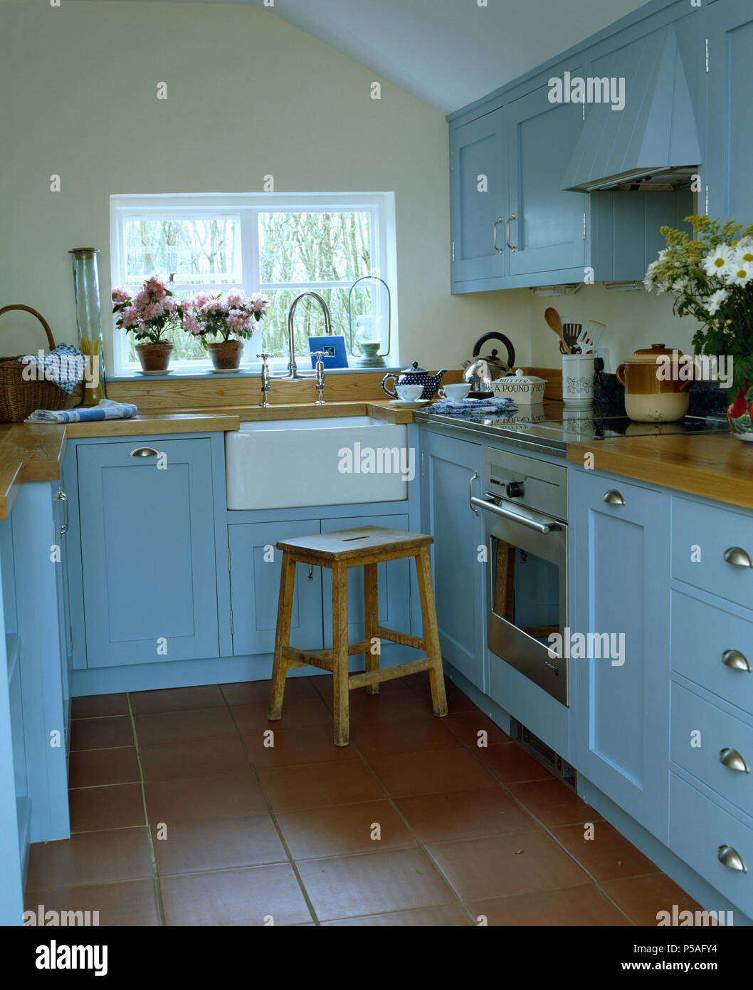 Kleine Küche mit cottsage Hellblau Einheiten und Steinbruch Fliesenboden Stockfoto