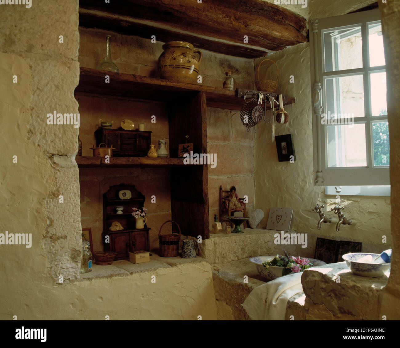 Holzfachböden in Alkoven im alten französischen Küche mit Waschbecken aus Stein unter Fenster Stockfoto