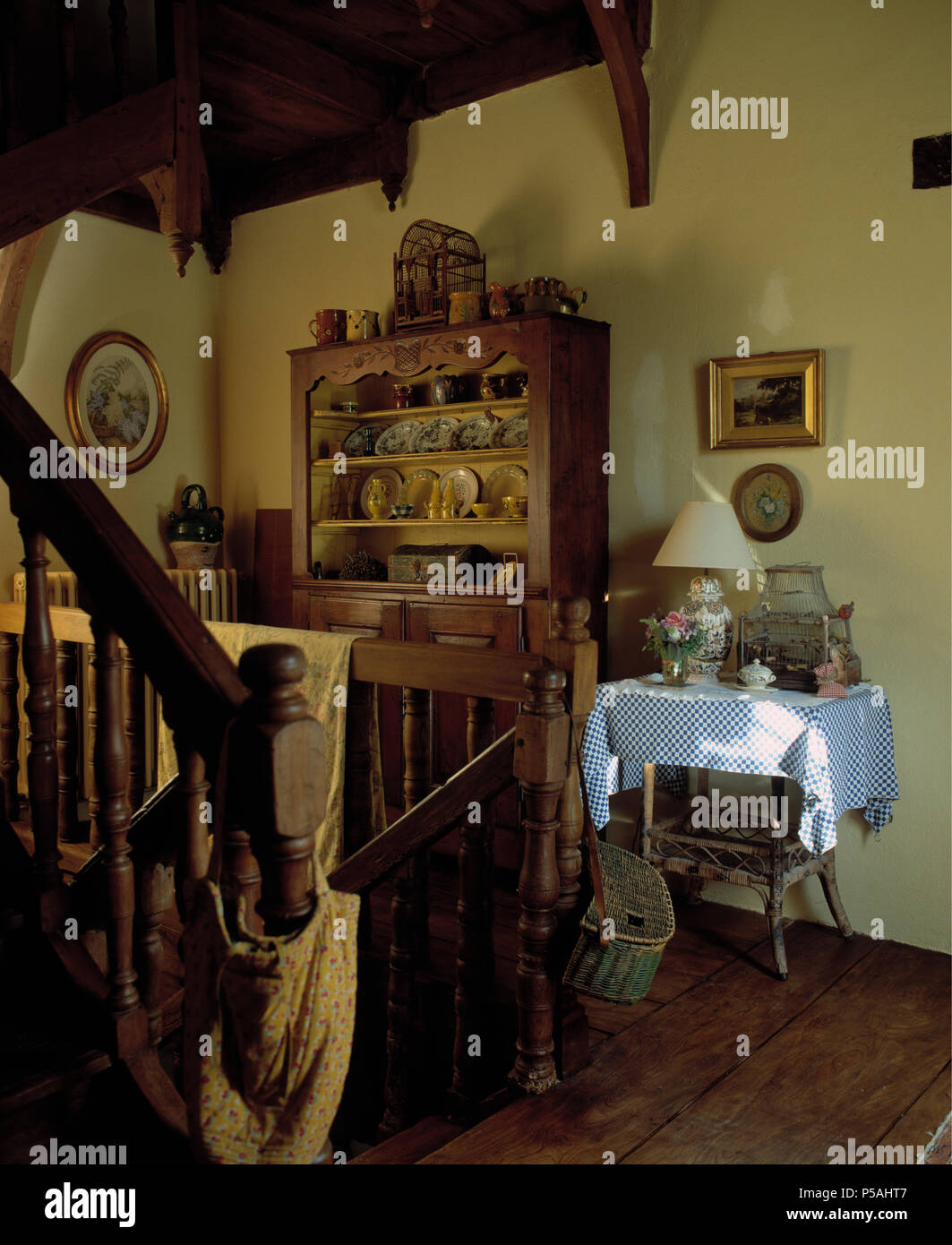 Alte kiefer Kommode und einem kleinen Tisch mit karierten Tuch in Französisch Land Küche mit Holztreppe Stockfoto
