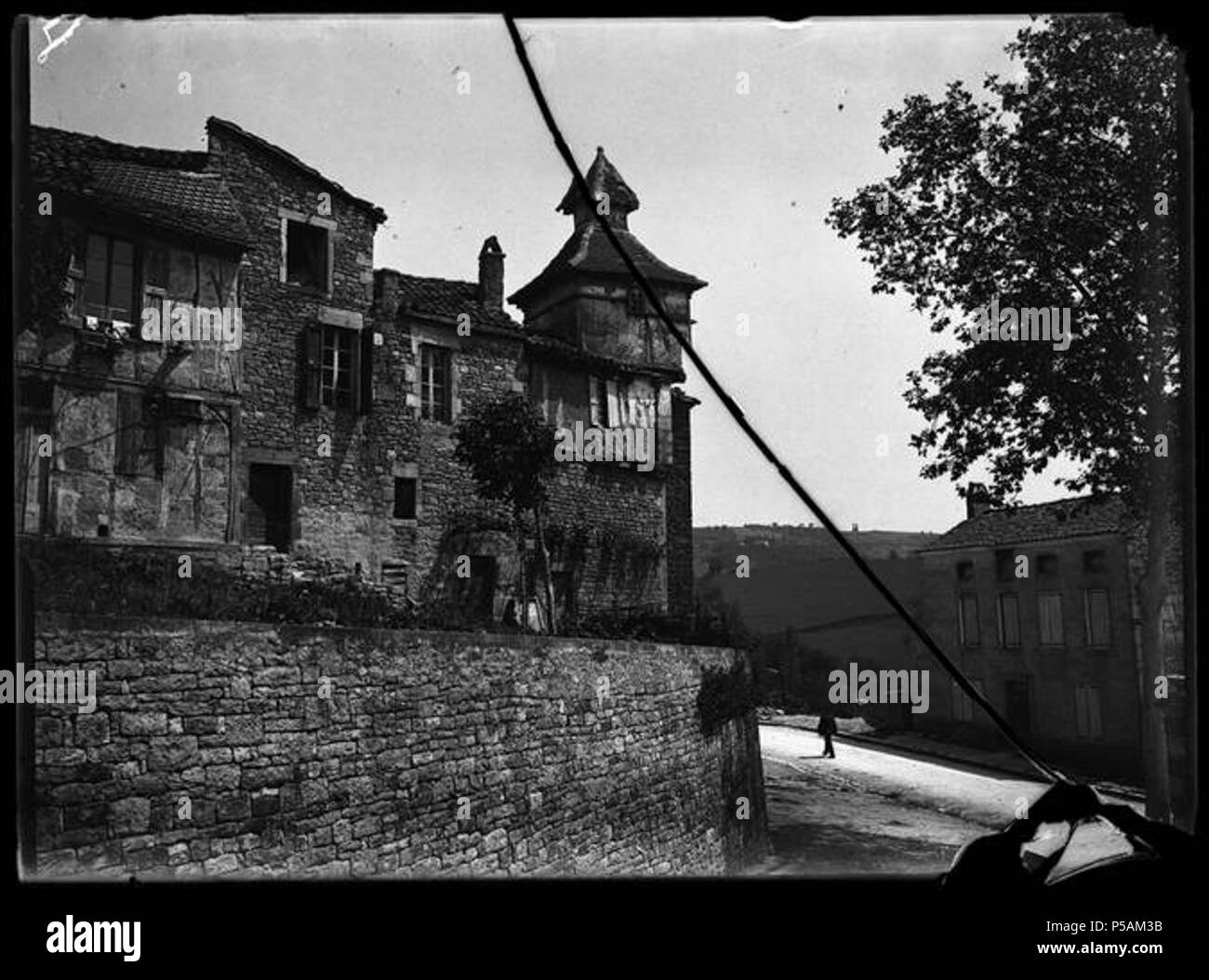 Français: Caylus. Vieux pigeonnier. 5 Juni 1906. Français: Caylus (Tarn-et-Garonne). 5 Juni 1906. Vue d'ensemble d'une Maison à l'extrémité de laquelle se trouve un Pigeonnier. Au zweiten Plan un homme Marchant dans la rue. . Am 5. Juni 1906 übernommen. N/A 284 Caylus. Vieux pigeonnier. 5 Juin 1906 (1906) - 51 Fi 127-Fonds Trutat Stockfoto