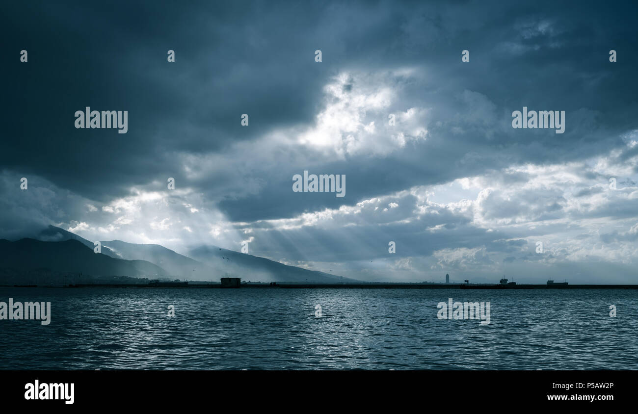 Dunkle Wolken und Sonne, Landschaft Hintergrund Foto. Bucht von Izmir, Türkei. Blau getönten Foto Stockfoto