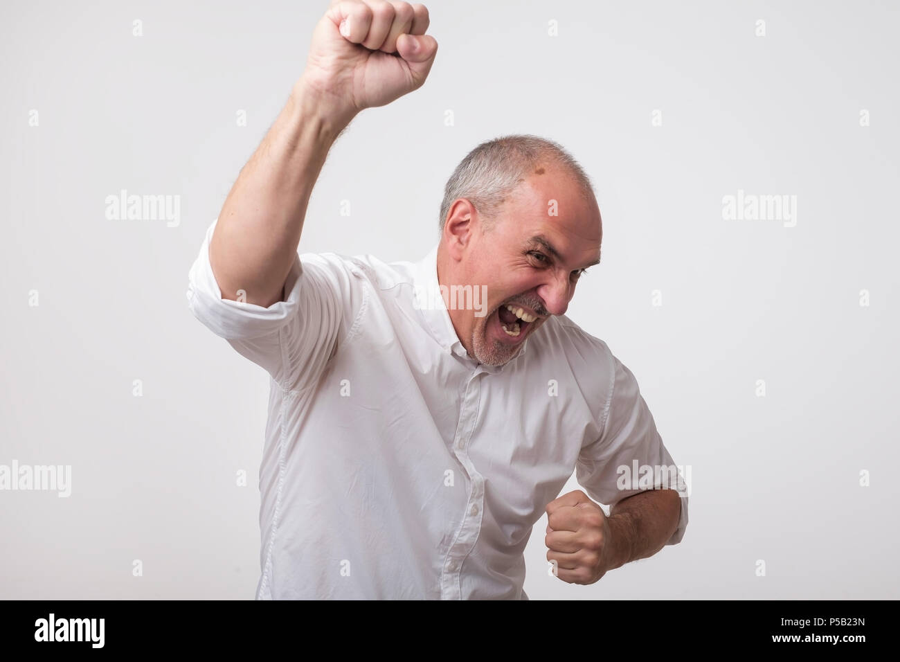 Portrait von reifen europäischen Mann mit den Fäusten. Er feiert das Gewinnen. Stockfoto