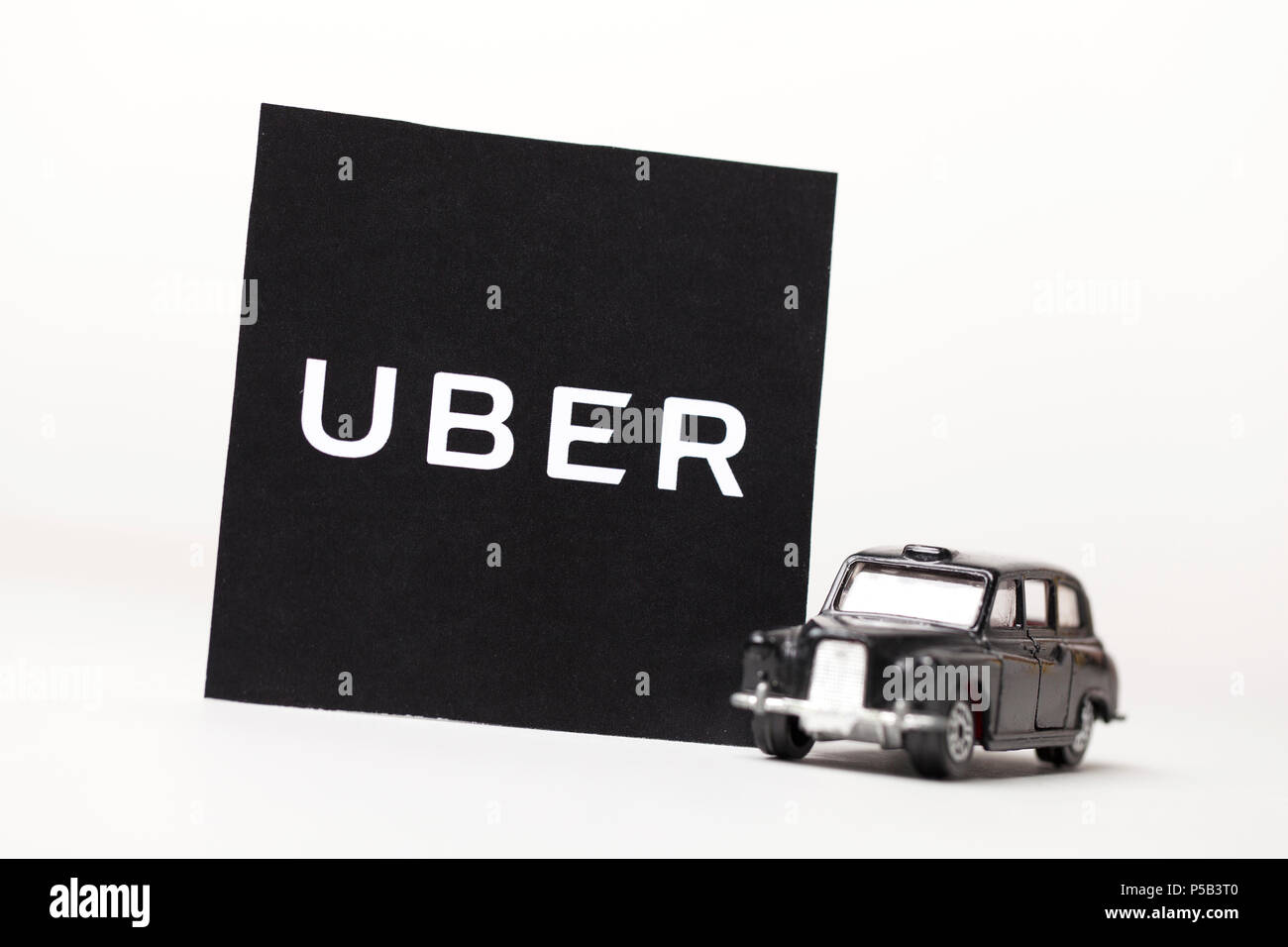 London, UK, 23. MÄRZ 2017: ein Foto des Uber Logo mit einem schwarzen London Style taxi Spielzeugauto. Uber ist ein beliebter Stil taxi transport Service App Stockfoto