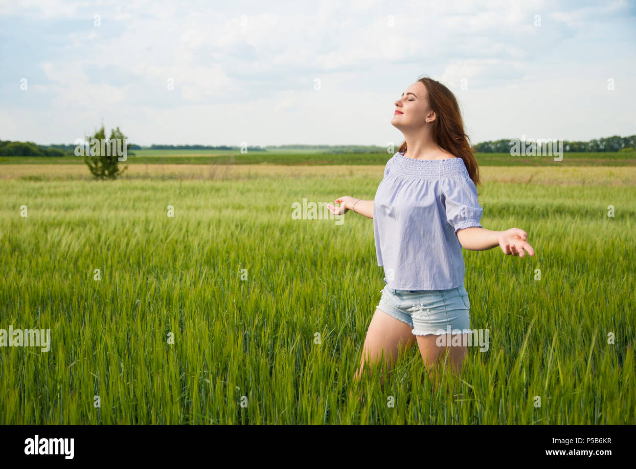 Happy schönes Mädchen in ein Feld die Natur genießen. Stockfoto