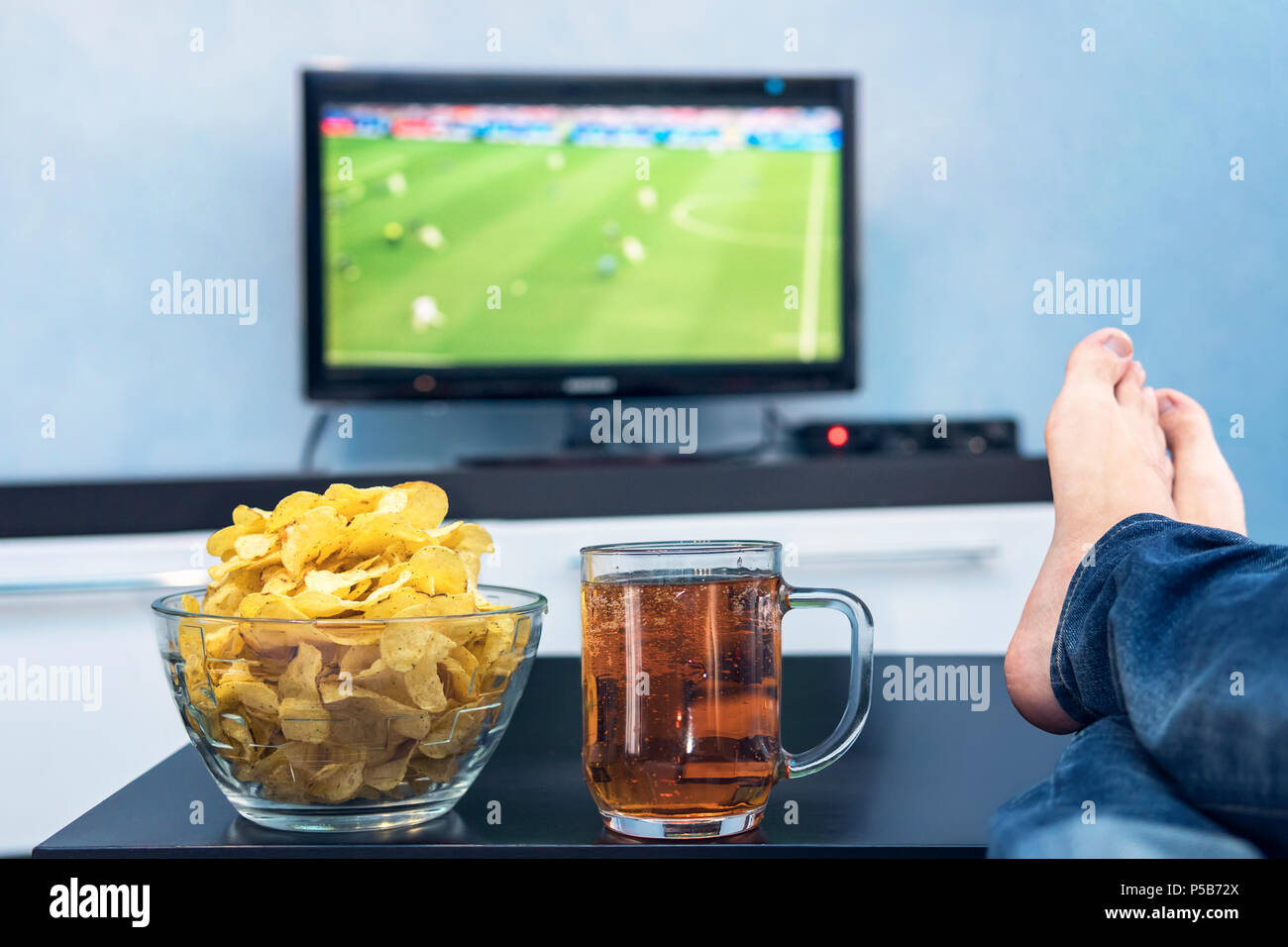 TV, Fernsehen, Fußball Match auf TV mit Snacks und Alkohol. vor dem  Fernseher entspannen. Ein Fan von gerade ein Fußballspiel spielen aus. Eine  Platte o Stockfotografie - Alamy