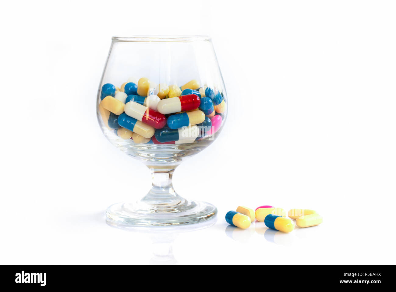 Bunte Pillen und Medikamente in einem Glas auf weißem Hintergrund, Gesundheit und Medikamente Konzept Stockfoto
