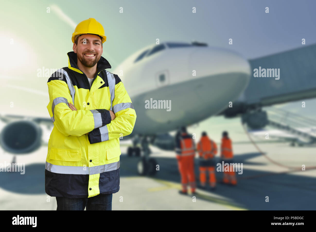 Portrait von lächelnden Arbeiter von bodenpersonal am Flughafen - Handhabung und Sicherheit die Kontrolle über ein Flugzeug Stockfoto