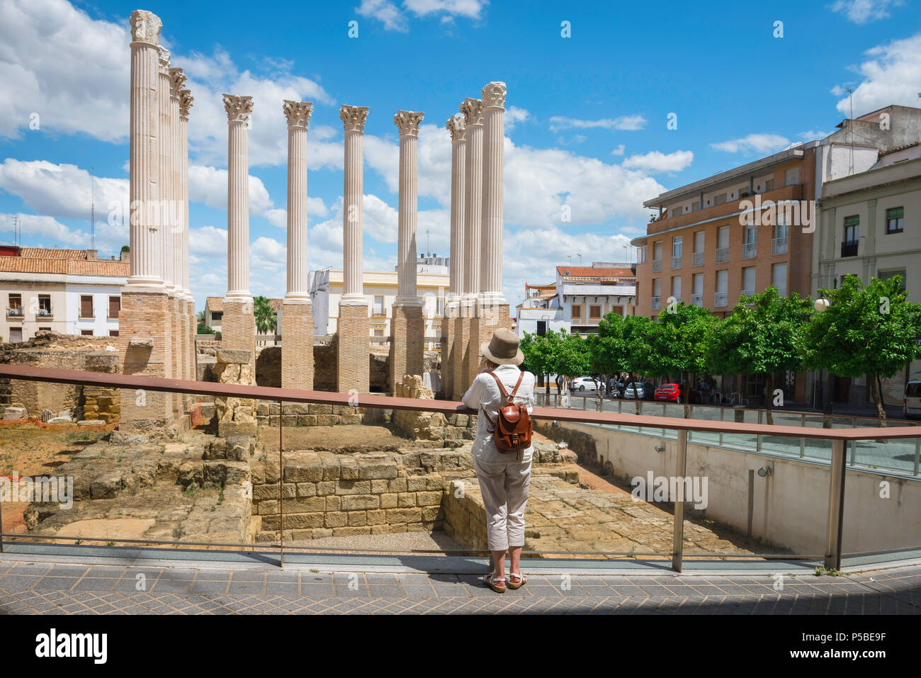Reife Frau reist allein, Rückansicht einer allein Reisenden, die die Ruinen eines antiken römischen Tempels in Cordoba, Andalusien, besucht, Stockfoto