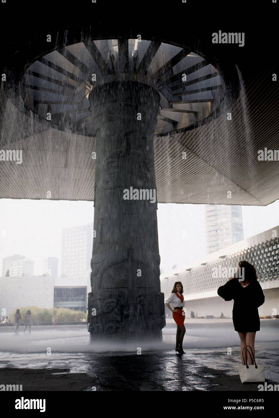 MODELO PUBLICITARIA REALIZANDO UNA SESSION DE FOTOS EN EL VESTIBULO DEL MUSEO CON LA FUENTE DE TLALOC O DIOS DE LA LLUVIA. Lage: MUSEO NACIONAL DE ANTROPOLOGIA, Mexiko-stadt, CIUDAD DE MEXICO. Stockfoto