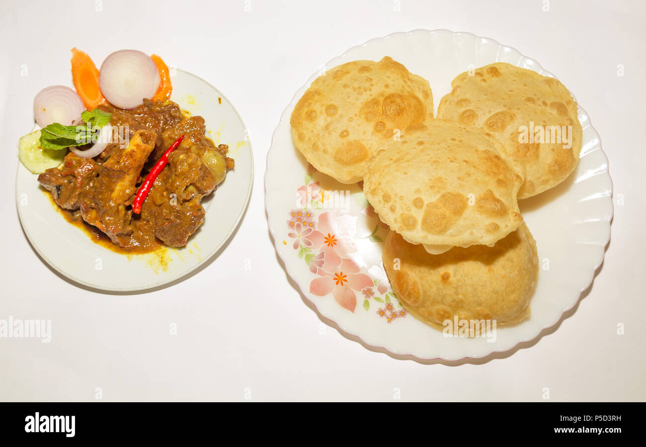 Traditionelle indische Mahlzeit - Poori aus Mehl mit pikanter Soße Hammel kosha serviert. Ein beliebtes indisches Essen. Stockfoto