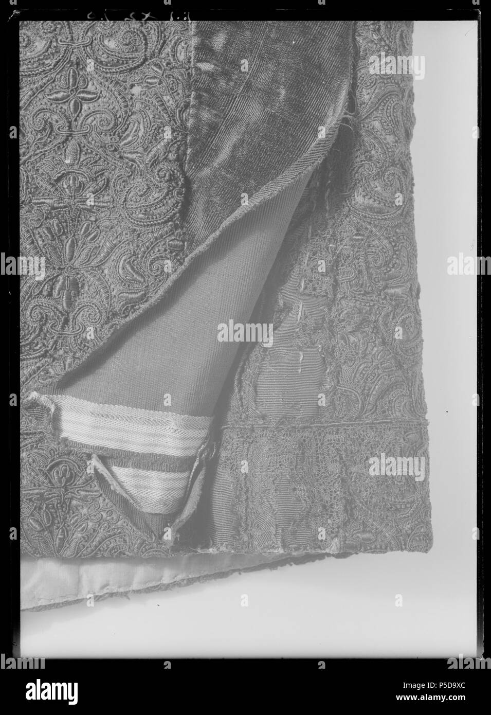 Byxor. Svenska: Av svart, slät Atlas broderad Med svart Silke. Byxorna ist broderade på Samma sätt som tröjan med Samma mönsterrapport ich broderiet, h: 11 cm, B: 9,8 cm. De ist av relativt snäv, rak Modell. Dessa byxor har, liksom Andra helt, broderade sytts Samman av4 större stycken, Männer dessutom Finnen de ytterst karaktäristiska skarvarna, Som satts in mitt Fram och mitt Bak, där de ist ca 30 cm långa och upptill ca 7 á 10 cm Breda och nedtill smalnar de av helt. Dessutom har skarvar satts in vid benstyckets inre Parti så att relativt rektangulära stycken av ca 8 cm bredd fogats Till varje styc Stockfoto