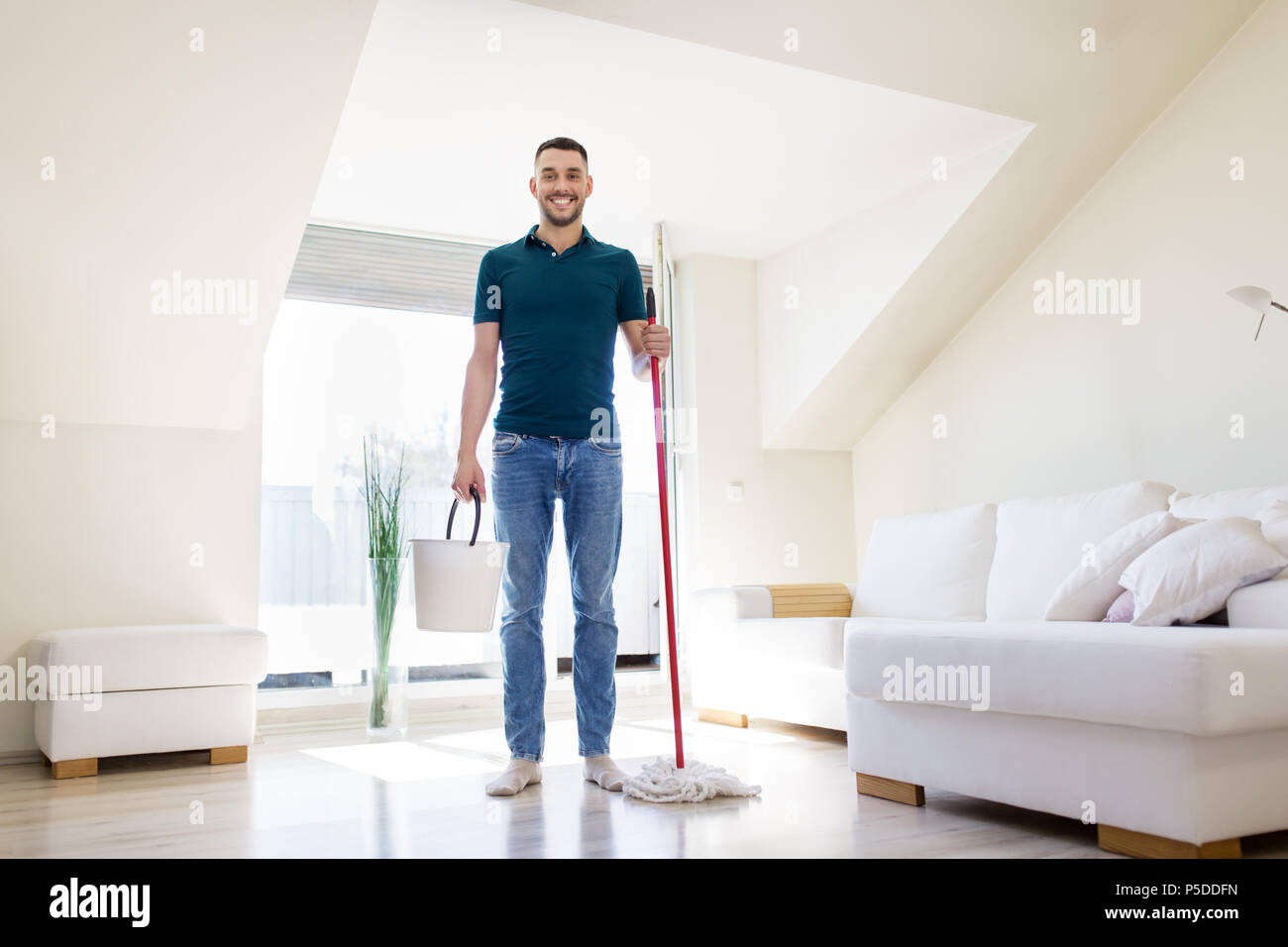 Mann mit Wischmopp und Eimer Reinigung Boden zu Hause Stockfoto