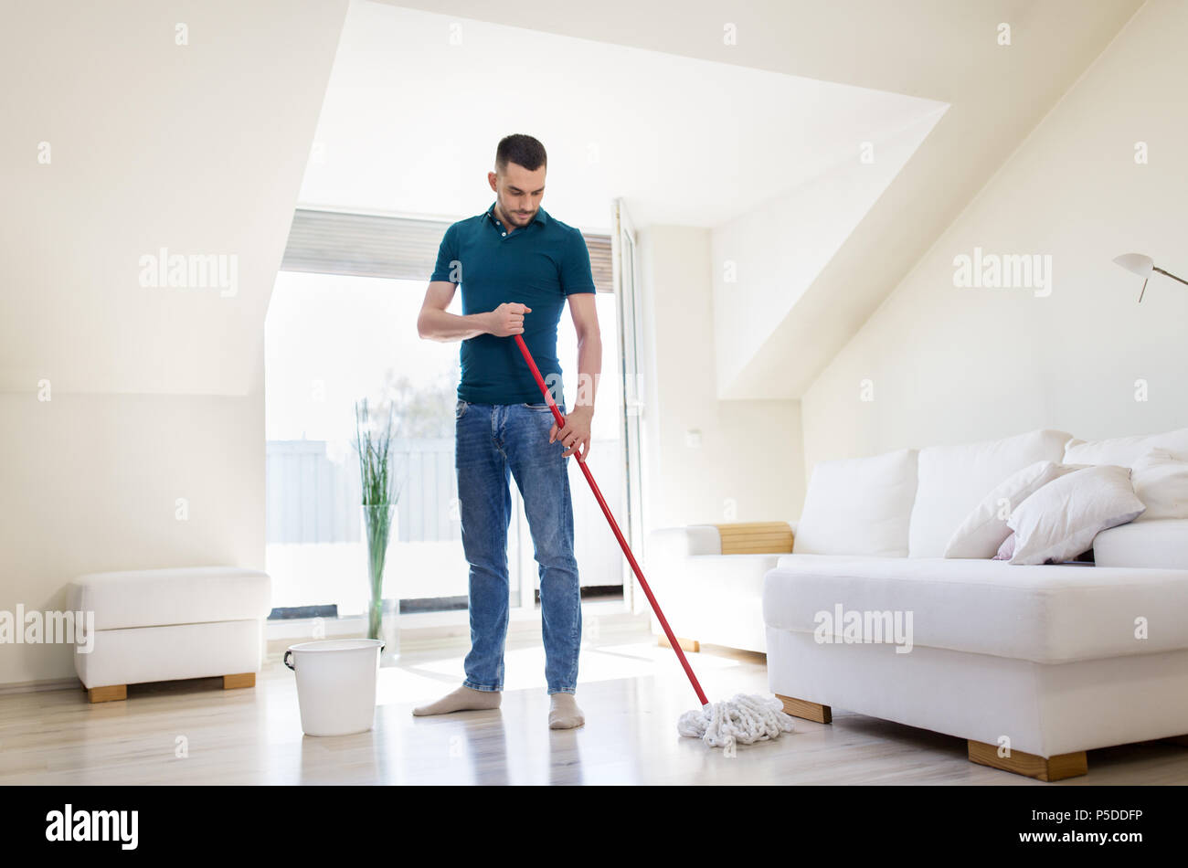 Mann mit Wischmopp und Eimer Reinigung Boden zu Hause Stockfoto